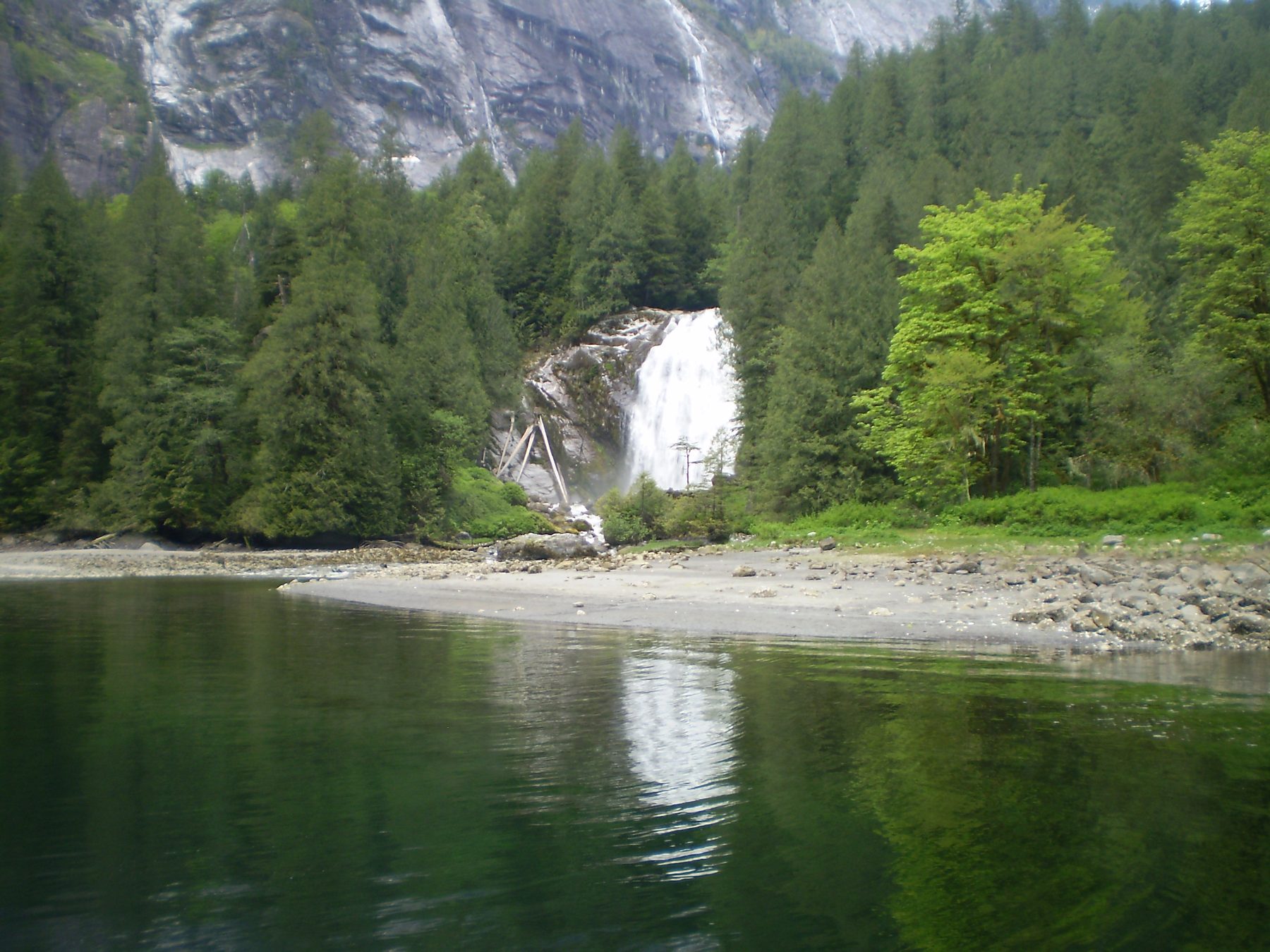 Chatterbox Falls tumbling into Princess Louisa Inlet, framed by rainforest.